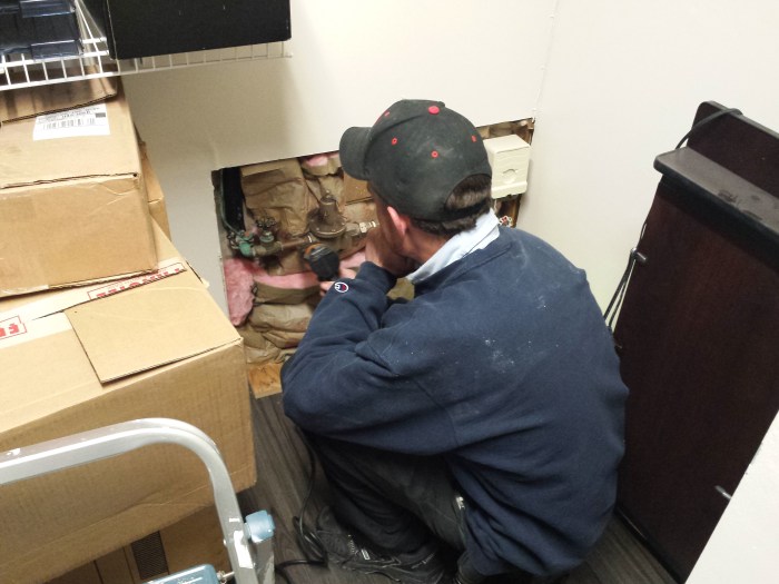 De monteur bezig met de waterleiding