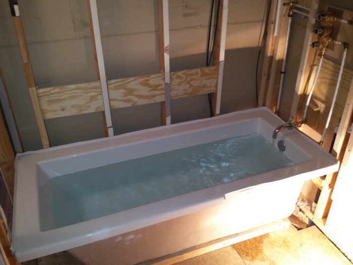 Testen of het allemaal waterdicht is. Dat witte randje langs de badrand is tile beading.