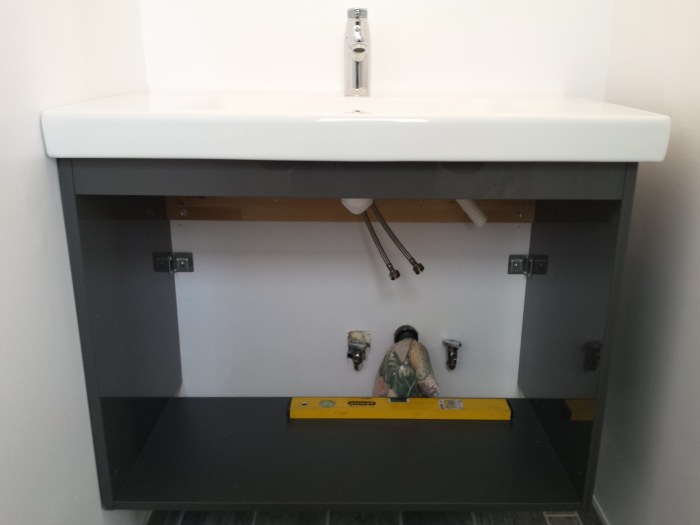 Het monteren van het badmeubel in de badkamer beneden