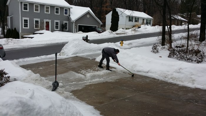 Michiel schoffelt het ijs van de oprit af. Het wordt lente!
