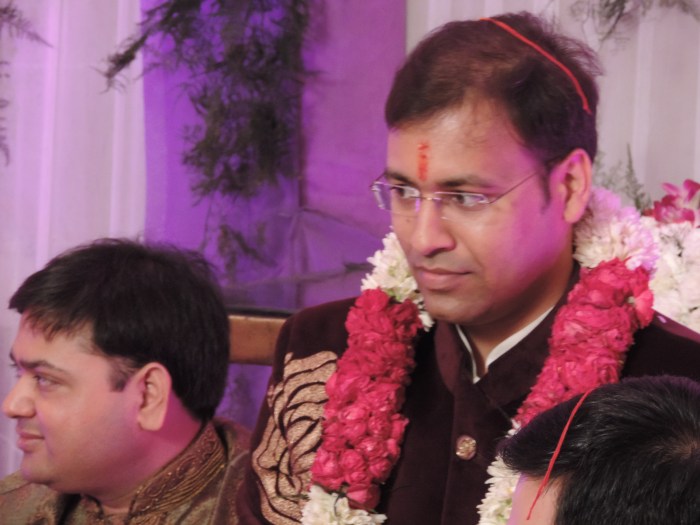 Pranav met touwtje op het hoofd, stip op het voorhoofd, en bloemenketting (allemaal traditie!)